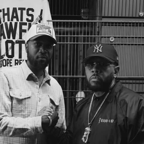 SCIENTIST and P.GUTTER side by side, hands clasped, in front of a metal gate and a banner reading “Thats a awful lotta Dope Records”